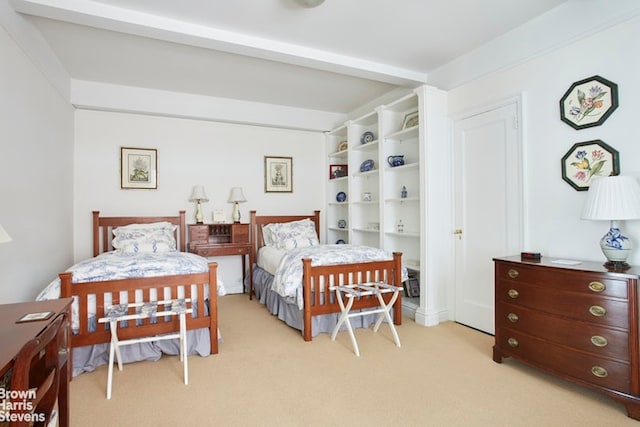 bedroom with light carpet and beamed ceiling