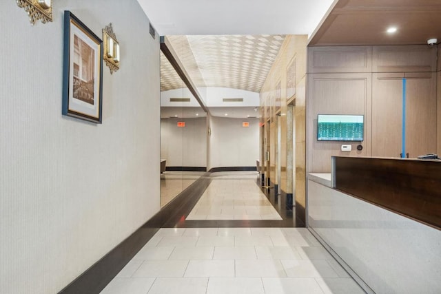 hall with brick ceiling, lofted ceiling, and light tile patterned floors