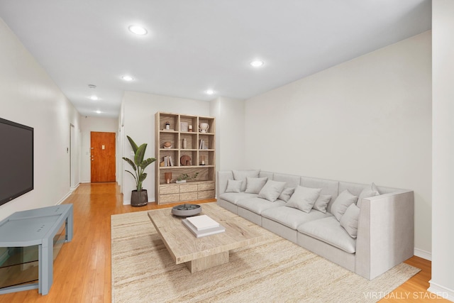 living room featuring recessed lighting, light wood-type flooring, and baseboards