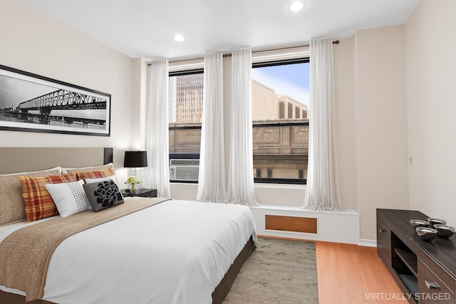 bedroom featuring recessed lighting, wood finished floors, and cooling unit