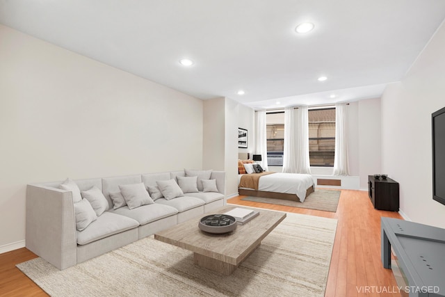 living area with recessed lighting, baseboards, and light wood-style flooring