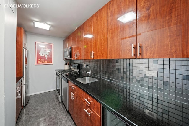 kitchen with dark stone countertops, appliances with stainless steel finishes, sink, and backsplash