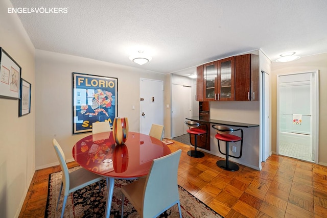 dining space with light parquet flooring and a textured ceiling