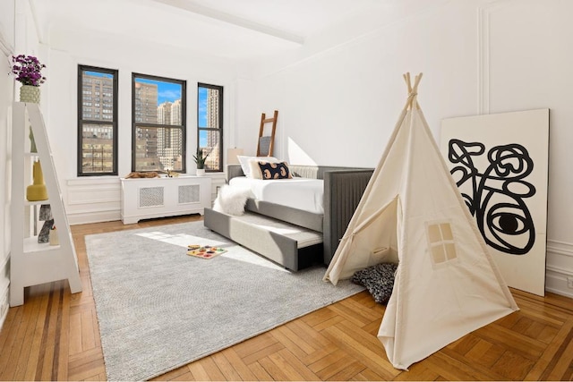 bedroom featuring beam ceiling and light parquet flooring