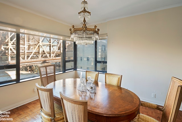 dining area with a wealth of natural light, a chandelier, baseboards, and ornamental molding