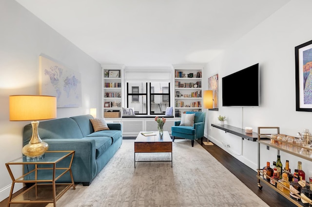 living room featuring wood finished floors and built in features