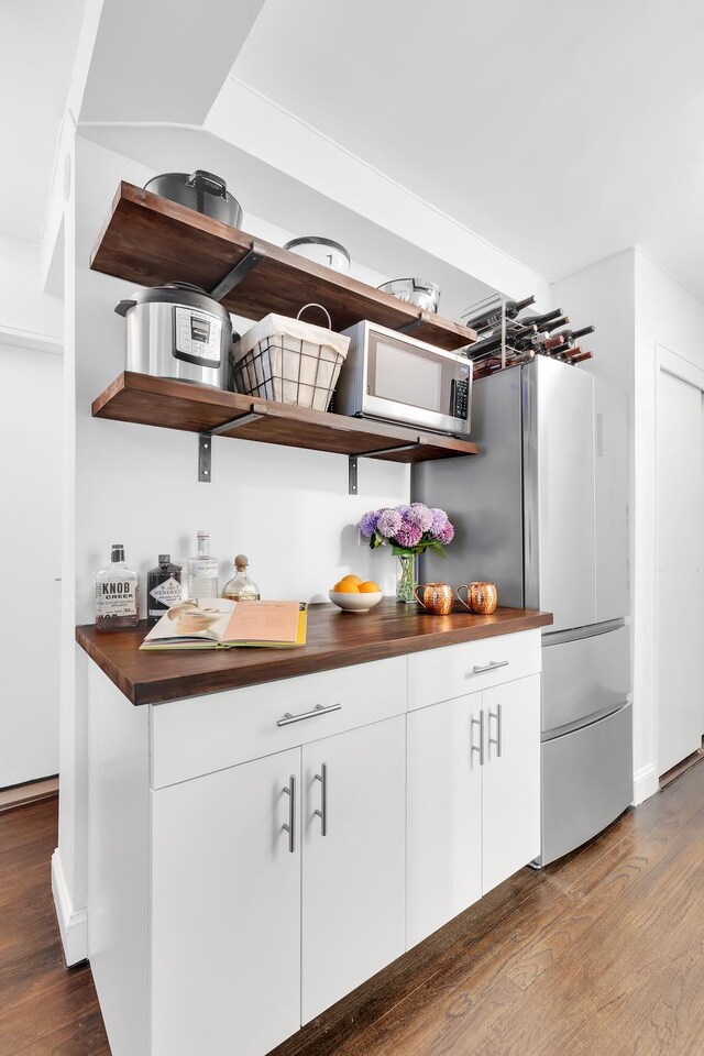 bar area with appliances with stainless steel finishes, dark wood finished floors, and baseboards