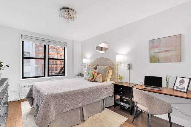 bedroom featuring wood finished floors, baseboards, and a desk