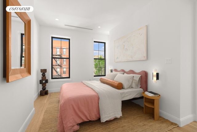 bedroom with recessed lighting, visible vents, baseboards, and wood finished floors