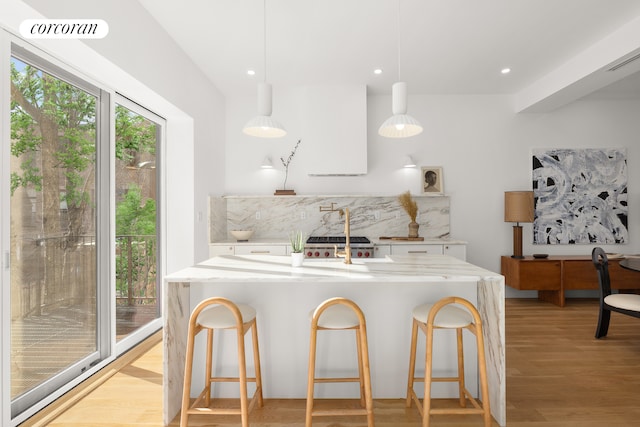 kitchen featuring tasteful backsplash, white cabinets, visible vents, and light wood-style flooring