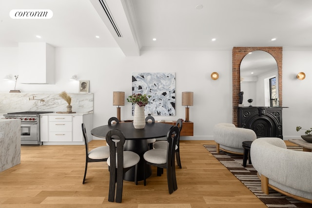 dining area featuring light wood-style flooring, a fireplace, visible vents, and recessed lighting