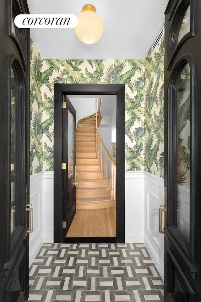 interior space featuring stairway, wainscoting, and wallpapered walls