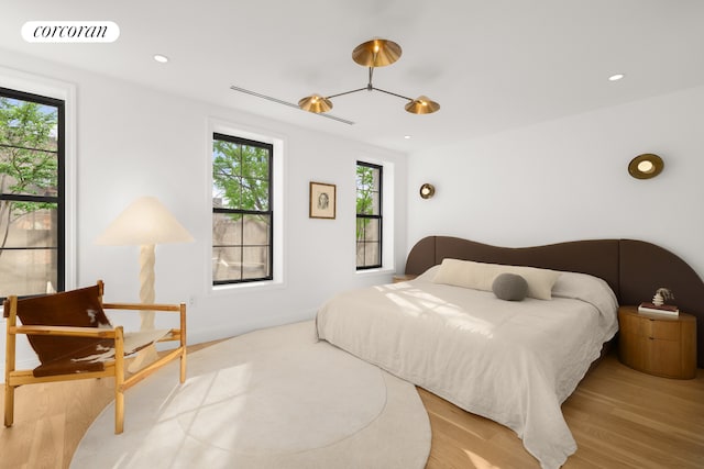 bedroom with light wood finished floors, visible vents, and recessed lighting