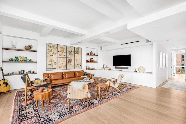 living room with beamed ceiling, built in features, and light hardwood / wood-style floors