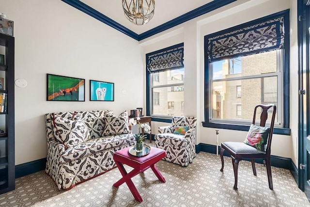 sitting room with crown molding and a chandelier