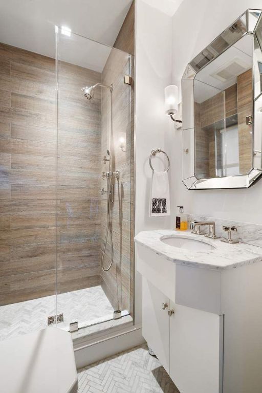 bathroom featuring a shower with door and vanity