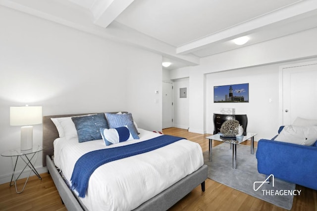 bedroom with hardwood / wood-style flooring and beam ceiling