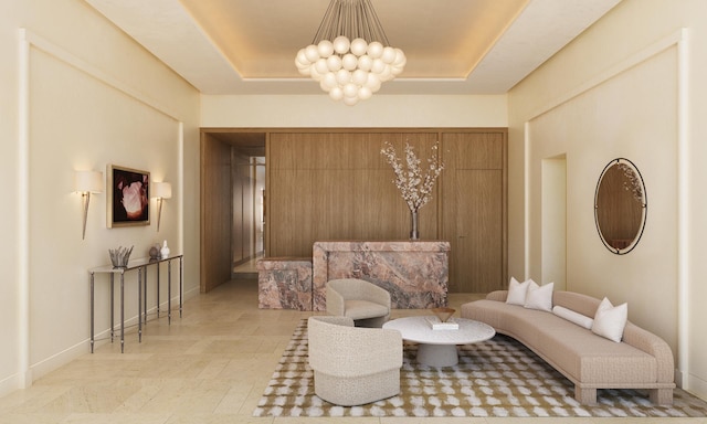 living area with a notable chandelier, a raised ceiling, and baseboards