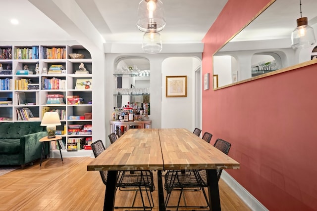 dining room featuring built in shelves and light hardwood / wood-style floors