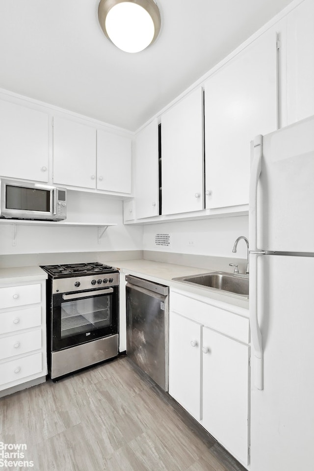 420 E 72nd St Unit 15D, New York City, NY 10021 - kitchen featuring appliances with stainless steel finishes, light countertops, and white cabinetry