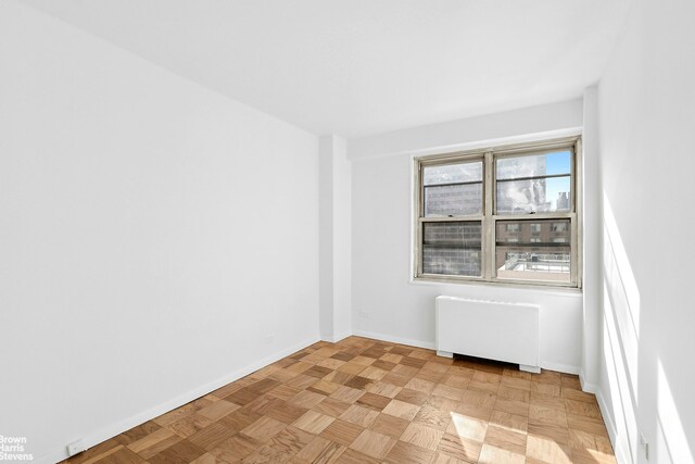 420 E 72nd St Unit 15D, New York City, NY 10021 - empty room with radiator heating unit and baseboards