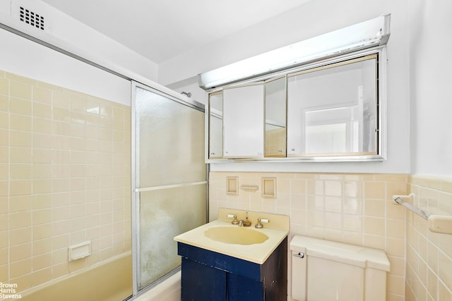 420 E 72nd St Unit 15D, New York City, NY 10021 - full bathroom with vanity, shower / bath combination with glass door, and tile walls