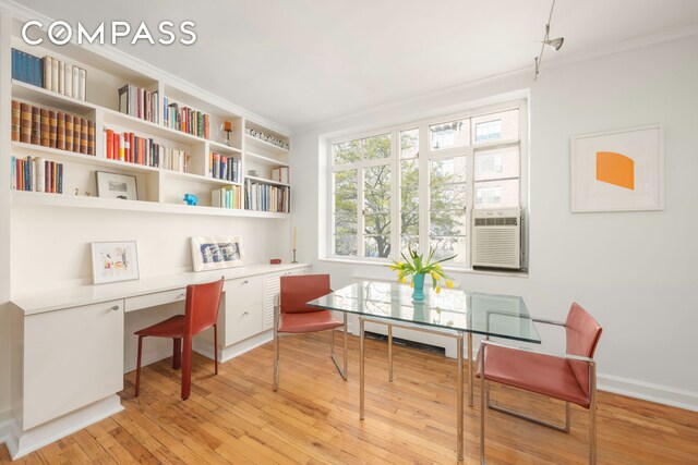 office with cooling unit, built in desk, and light hardwood / wood-style floors