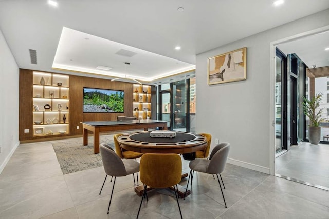 recreation room featuring a tray ceiling