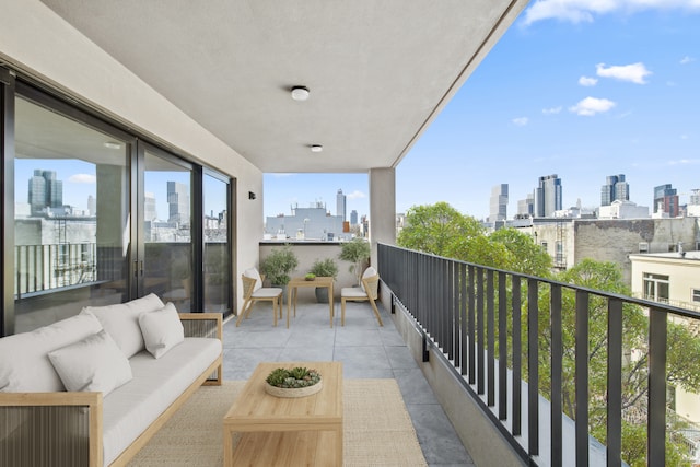 balcony featuring a view of city, a sink, and an outdoor living space