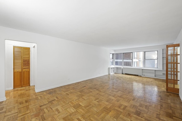 unfurnished living room featuring baseboards