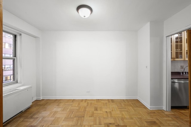 empty room featuring radiator heating unit and baseboards