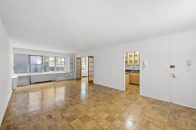 unfurnished living room with baseboards