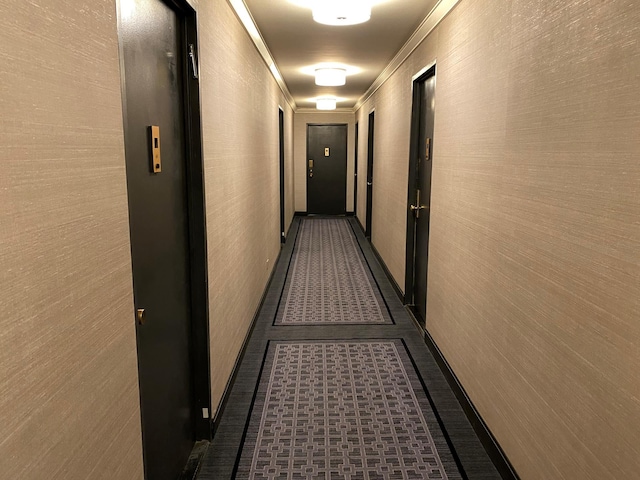 hallway featuring a textured wall and crown molding