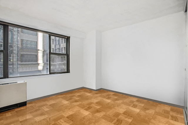 unfurnished room featuring radiator heating unit