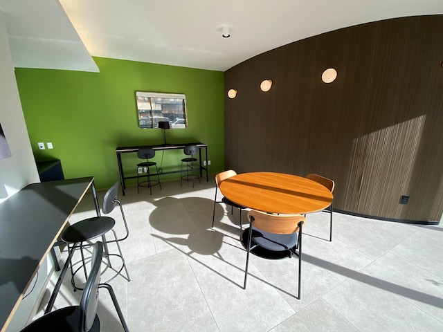 dining space with an accent wall and light tile patterned floors