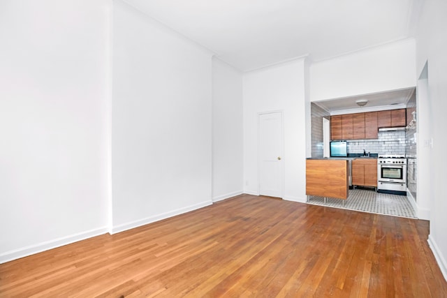 unfurnished living room featuring baseboards and hardwood / wood-style floors