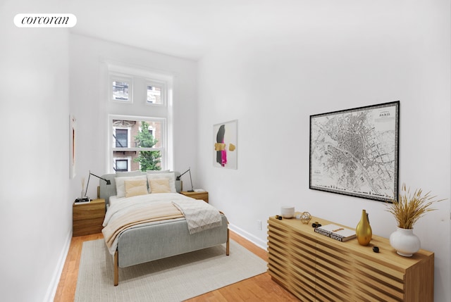 bedroom featuring baseboards, light wood-style flooring, and visible vents