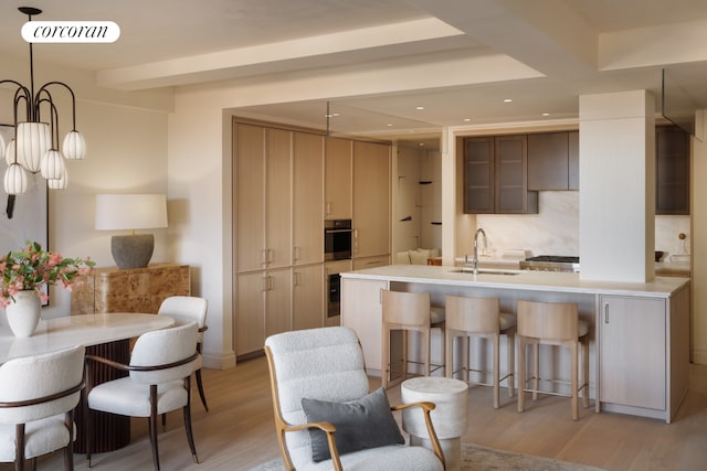 720 W End Ave Unit 8B, New York City, NY 10025 - kitchen with a breakfast bar area, wall oven, a peninsula, a sink, and light wood finished floors