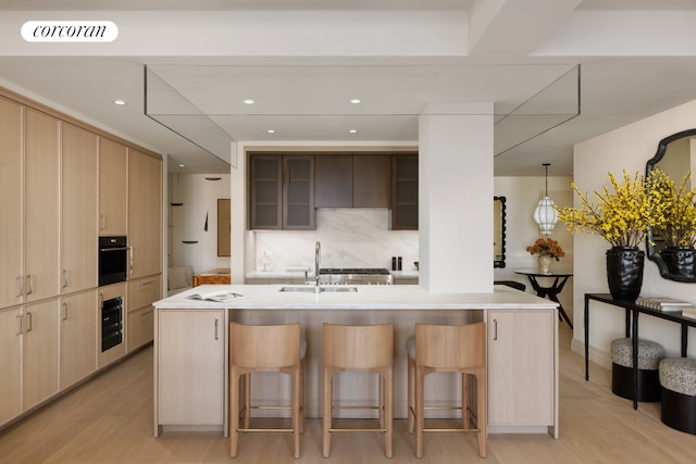 720 W End Ave Unit 8B, New York City, NY 10025 - kitchen with a kitchen breakfast bar, oven, light countertops, light wood-style floors, and a sink