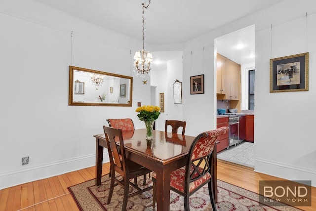 dining space with a chandelier and light wood-type flooring