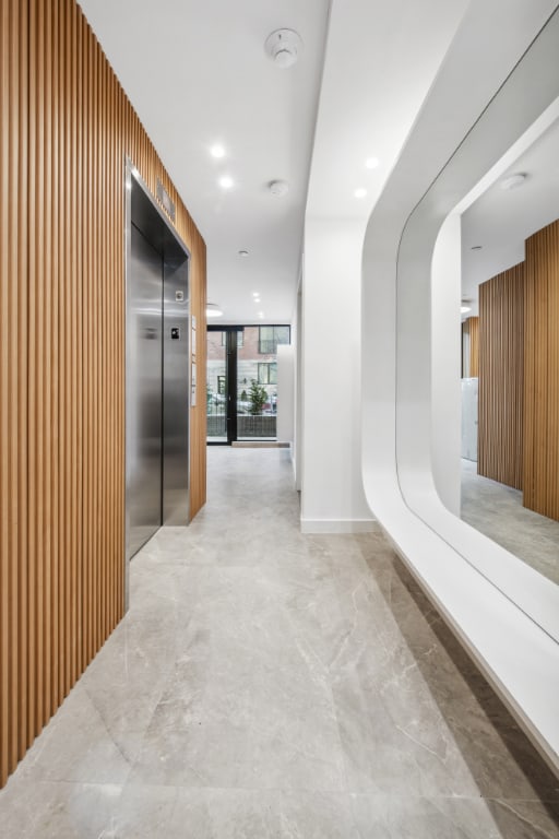 hall featuring expansive windows, elevator, and wood walls