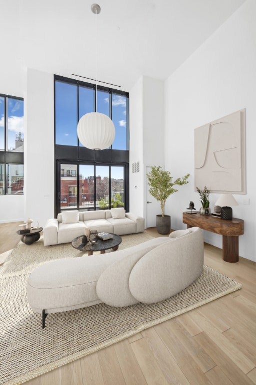 living room with hardwood / wood-style flooring, expansive windows, and a high ceiling