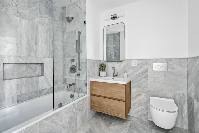 full bathroom with vanity, toilet, tiled shower / bath combo, and tile walls