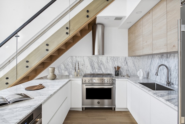 kitchen featuring stainless steel range, open shelves, backsplash, and a sink