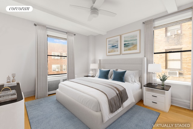 bedroom with beam ceiling, visible vents, baseboards, and wood finished floors