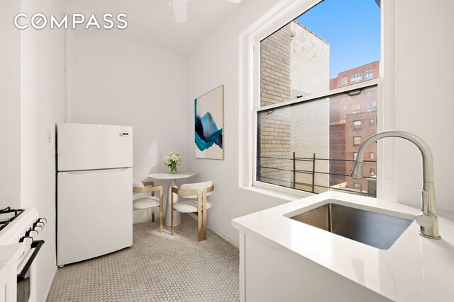 kitchen featuring sink, white fridge, and stove