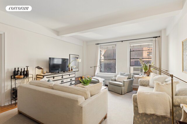 living room with radiator heating unit and beamed ceiling