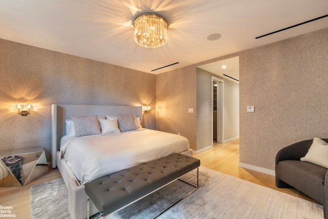 bedroom with hardwood / wood-style flooring and a notable chandelier