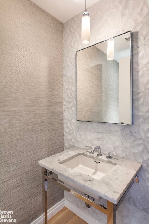 bathroom featuring sink and tile walls