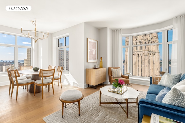 interior space featuring baseboards, light wood-style flooring, visible vents, and a notable chandelier